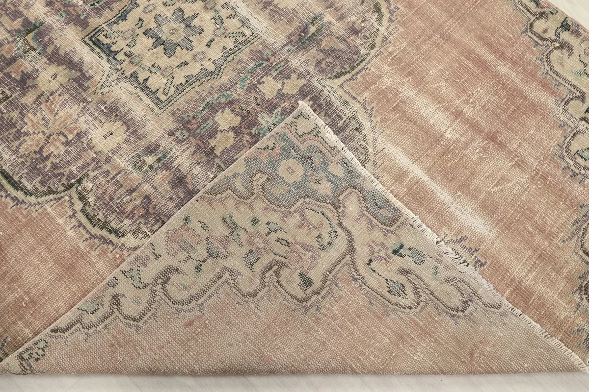Folded corner revealing the hand-knotted cotton foundation and reverse side of the rug