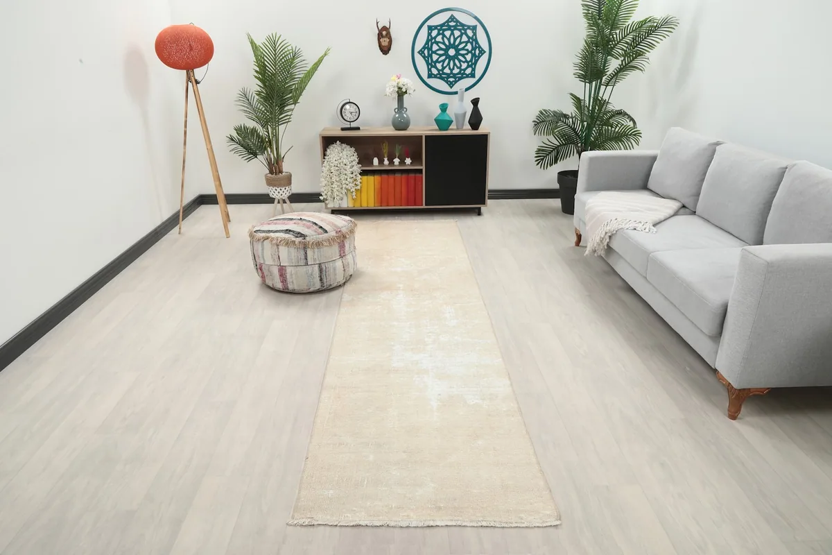 Beige vintage runner rug laid out in a modern living room setting, viewed from a wide angle.