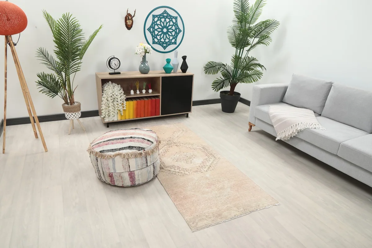 Angled view of the beige and rose runner rug in a room, highlighting its placement and colors.
