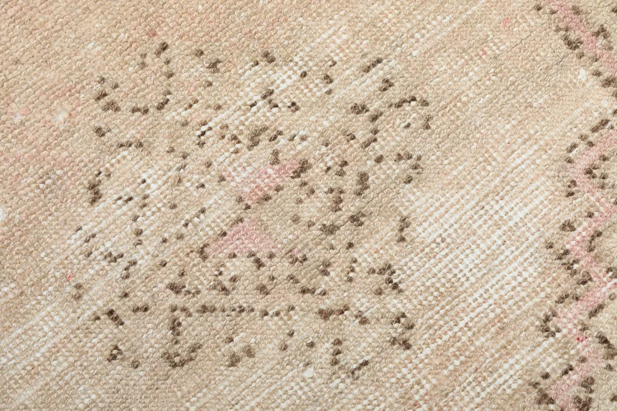 Detailed view of the hand-knotted wool pile and the intricate, faded geometric motifs.