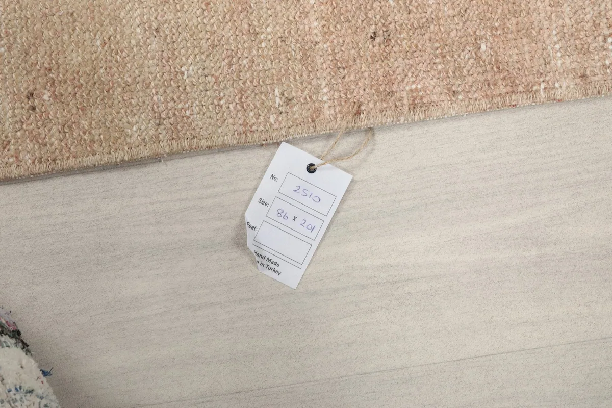 Close-up of the product tag displaying the rug's dimensions in centimeters and inches.