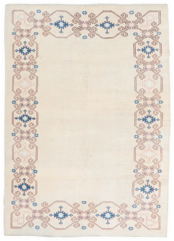 Top-down view of the 5'6" x 7'7" ivory vintage Anatolian rug with blue, pink, and rust border