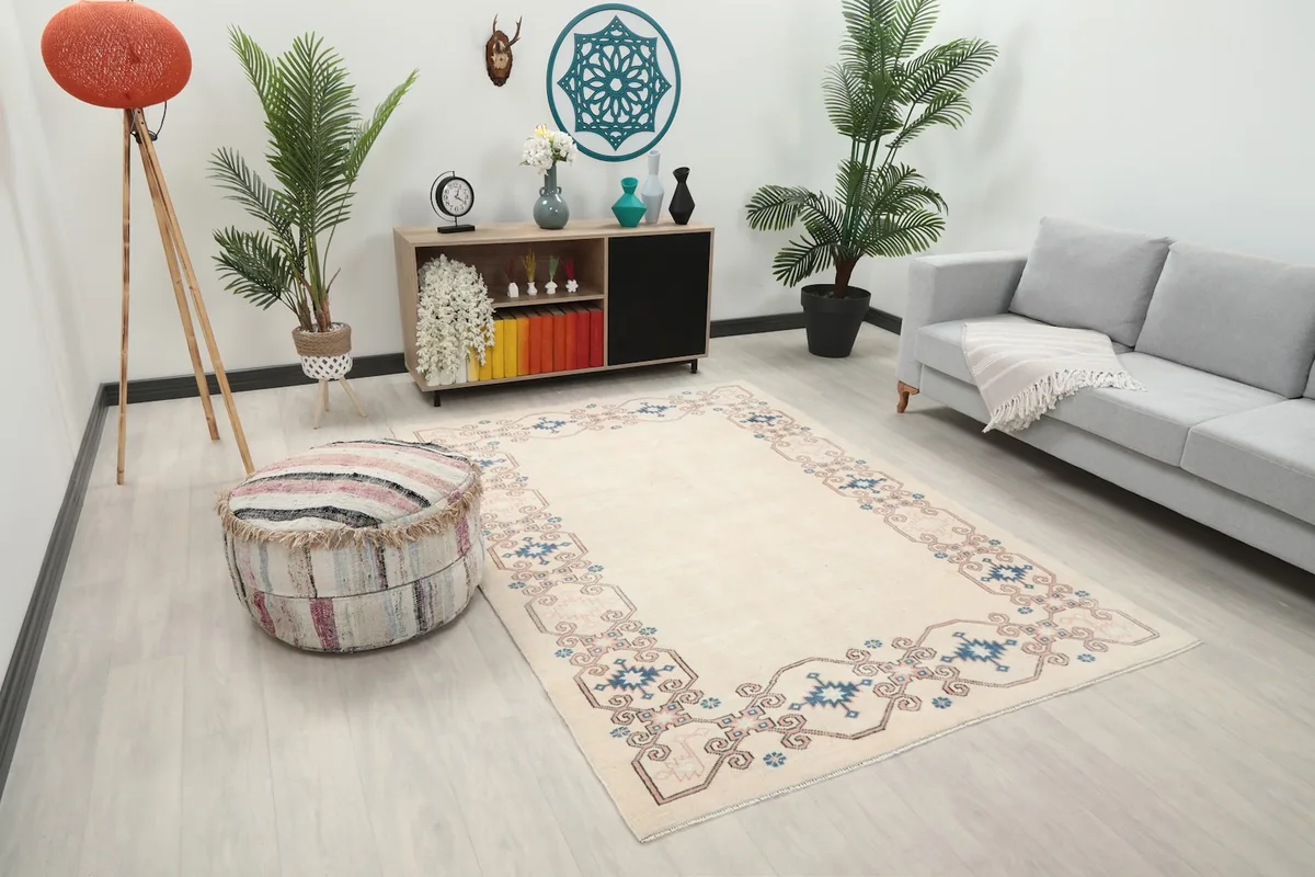 Angle view of the ivory area rug in a modern living space with plants and a decorative ottoman