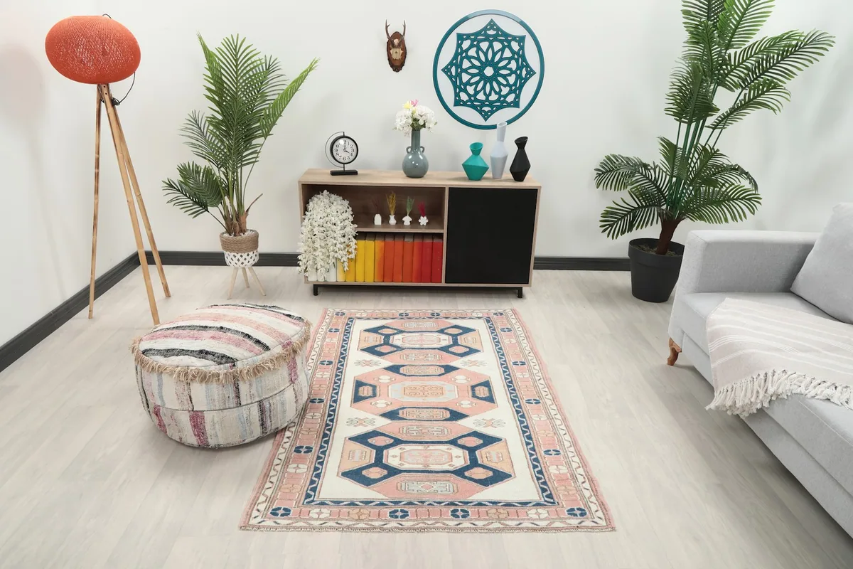 Vintage Anatolian rug displayed in a bright living room setup with a grey sofa and wooden console