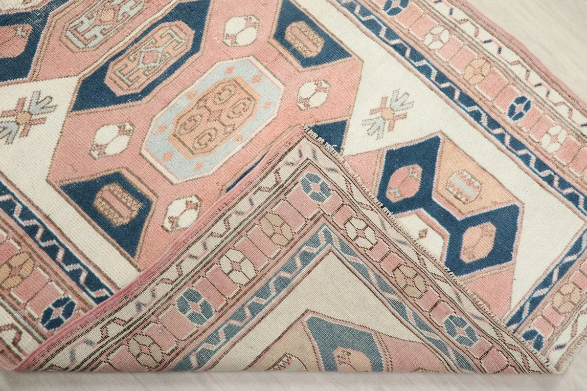 Folded corner of the rug, revealing the soft texture of the wool pile and cotton foundation