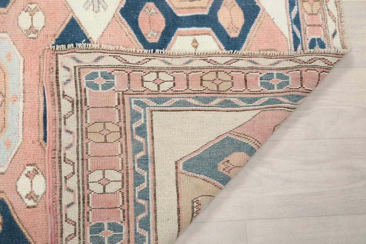 Another view of the rug's folded corner, showing the back of the hand-knotted construction