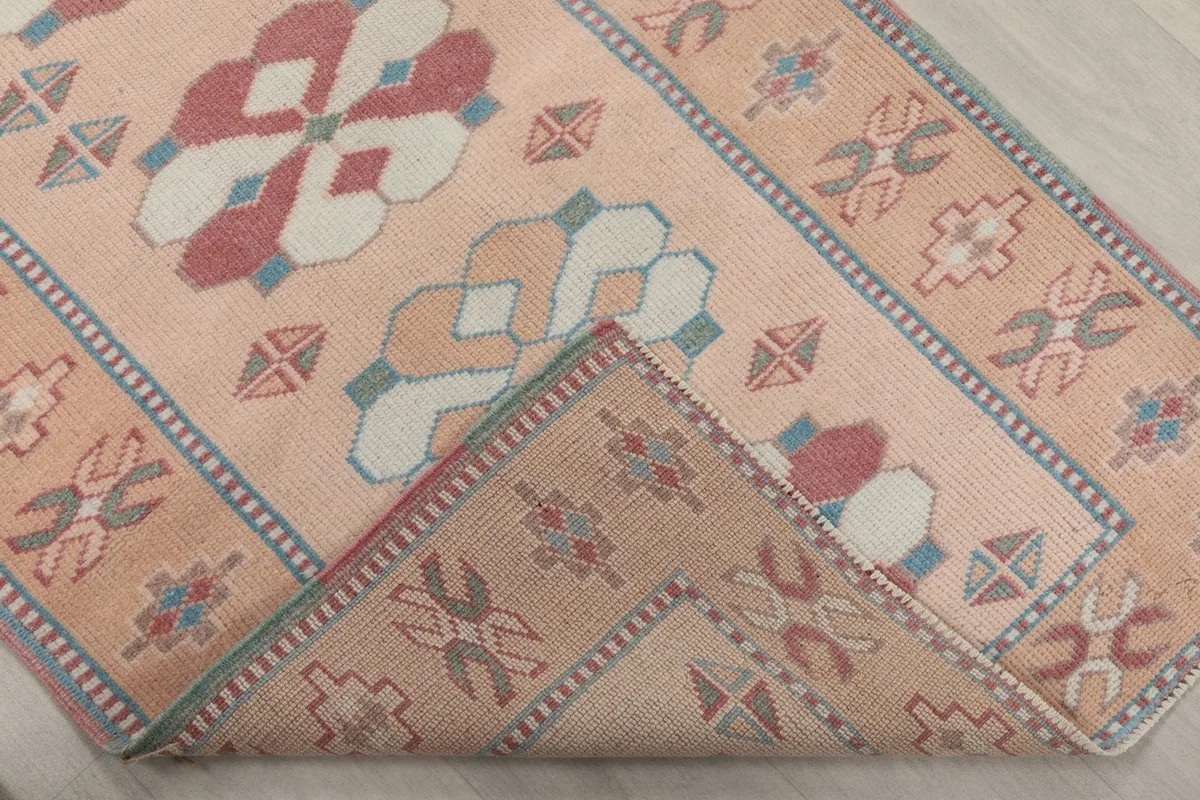 Corner of the runner rug folded back to reveal the back of the weave