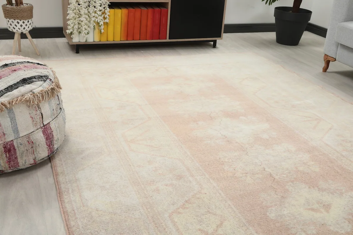 Close-up angle showing the rose central medallion and cream field of the vintage Anatolian rug.