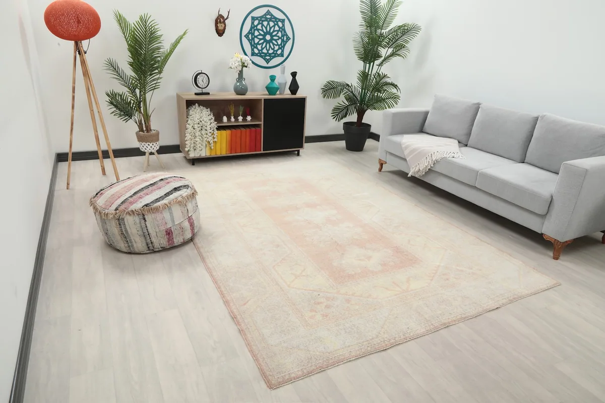 Angle view of the rose and cream Anatolian rug laid out in a living space, showcasing its size.