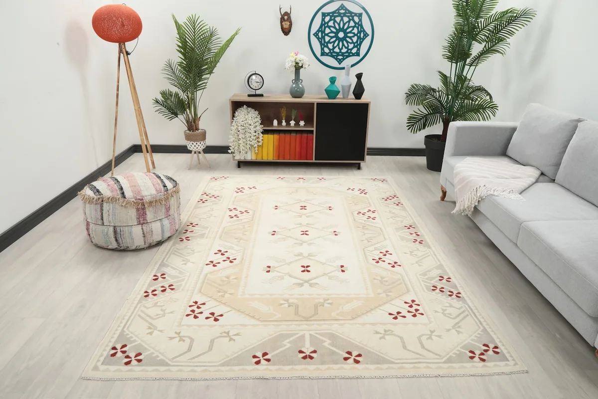 Ivory red tribal rug displayed in a bright living room setup with a sofa and decor.