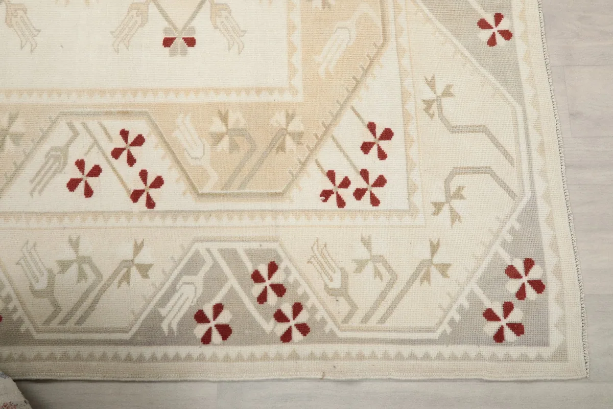 Detailed view of the rug's beige and gray border with intricate tribal motifs.