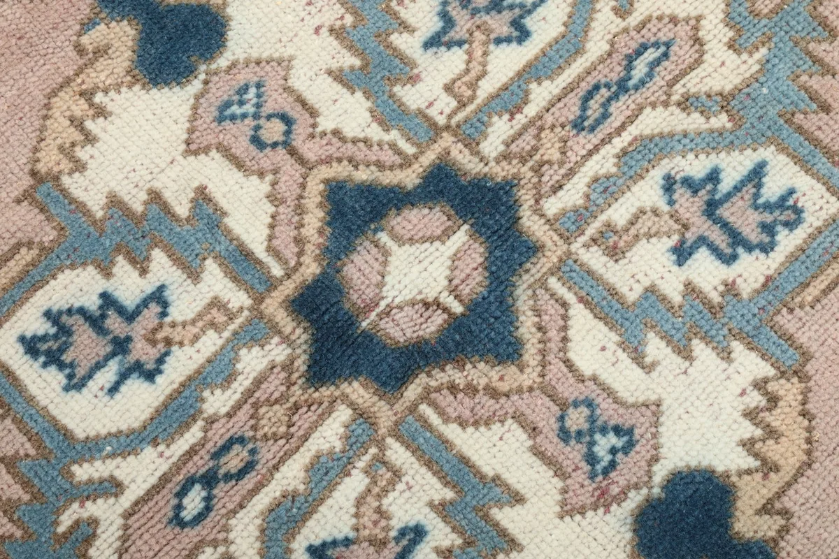 Extreme close-up of the central medallion's intricate navy, blue, and ivory knotting