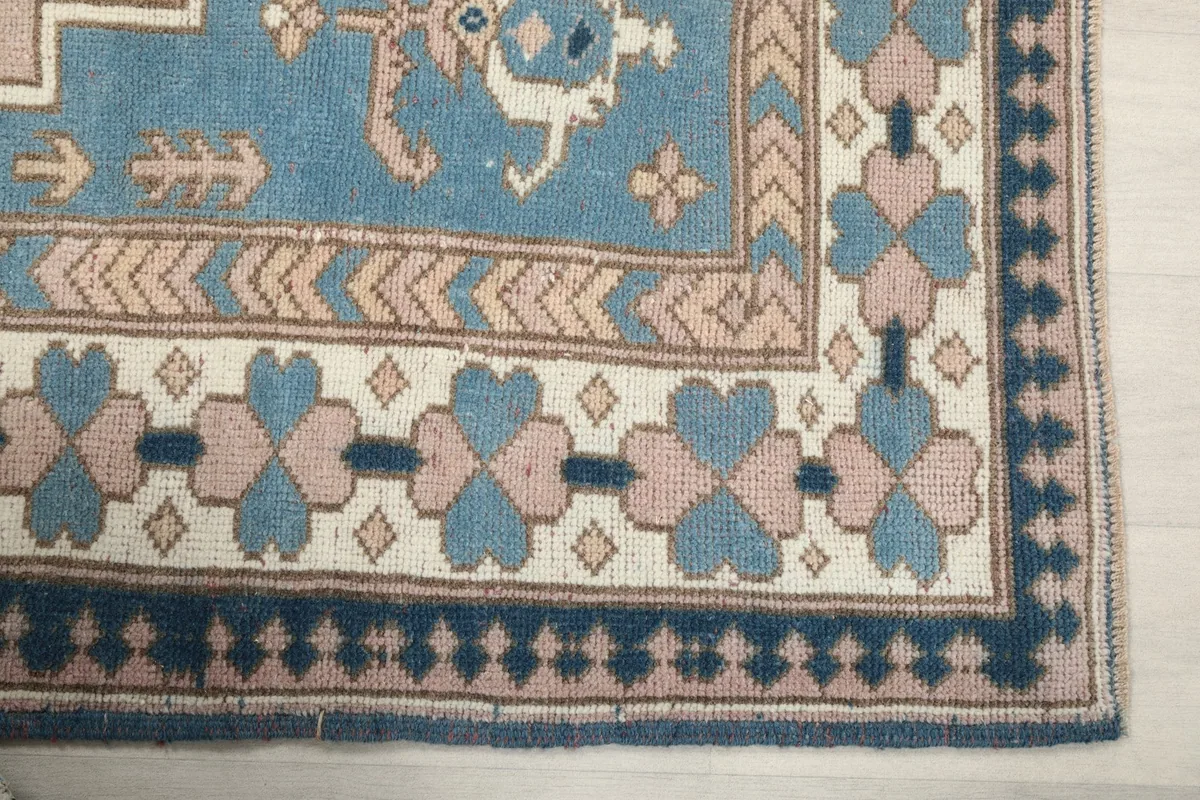 Detailed view of the corner border, showing blue, pink, and ivory geometric patterns