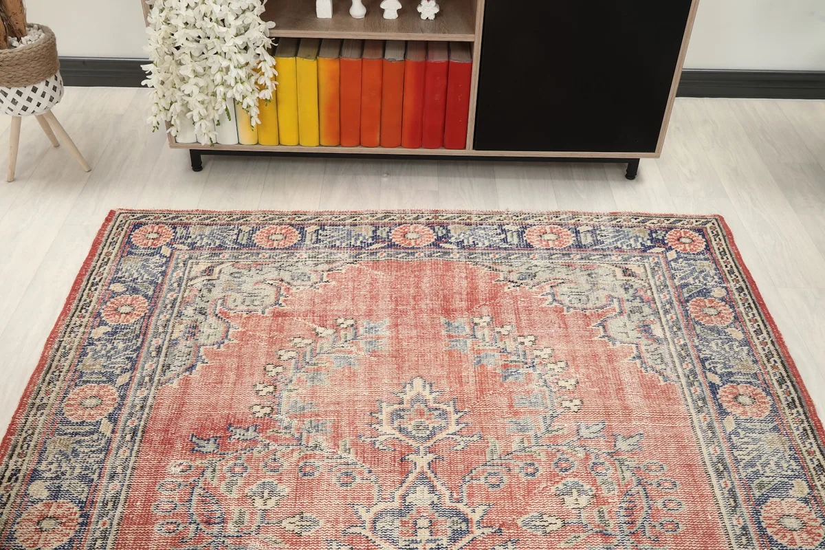 View of the rug in a living space, looking towards a wooden cabinet