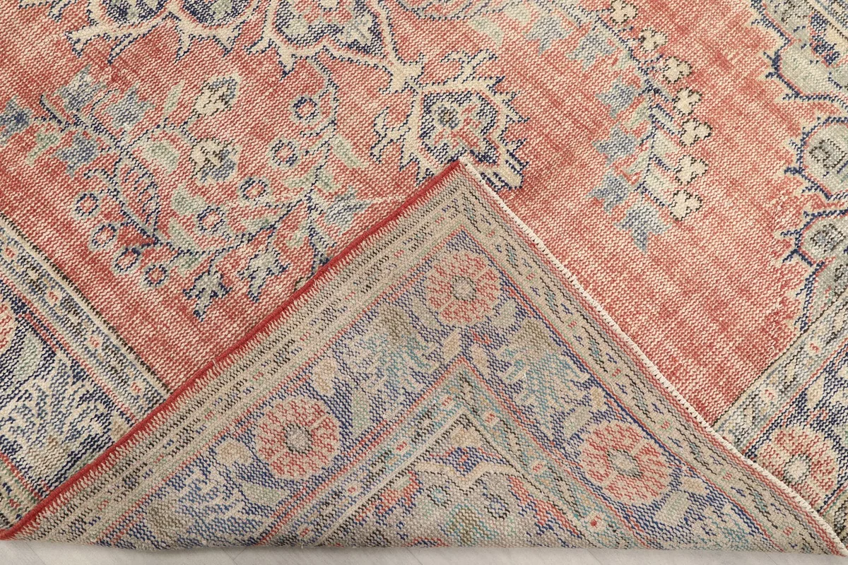 Folded corner of the rug, revealing the back of the weave and pile height