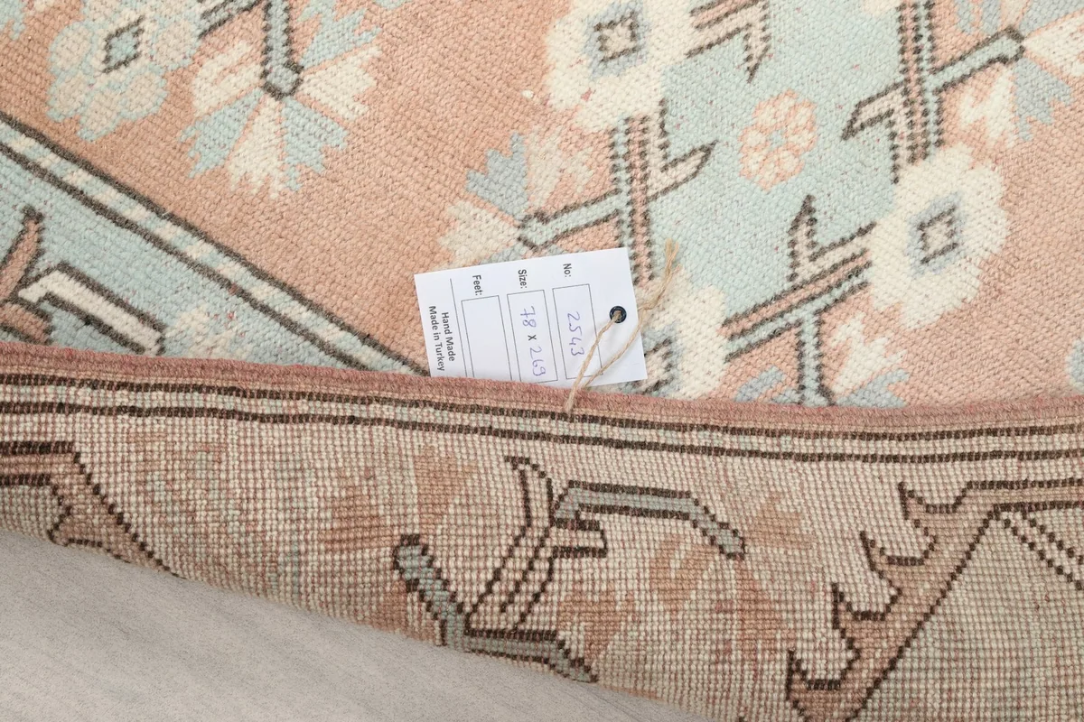 Close-up of the rug's back and a tag, indicating its origin and material details