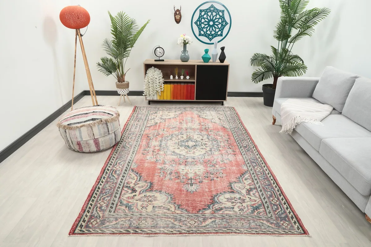 Vintage rose area rug displayed in a bright living room setting with a light gray sofa
