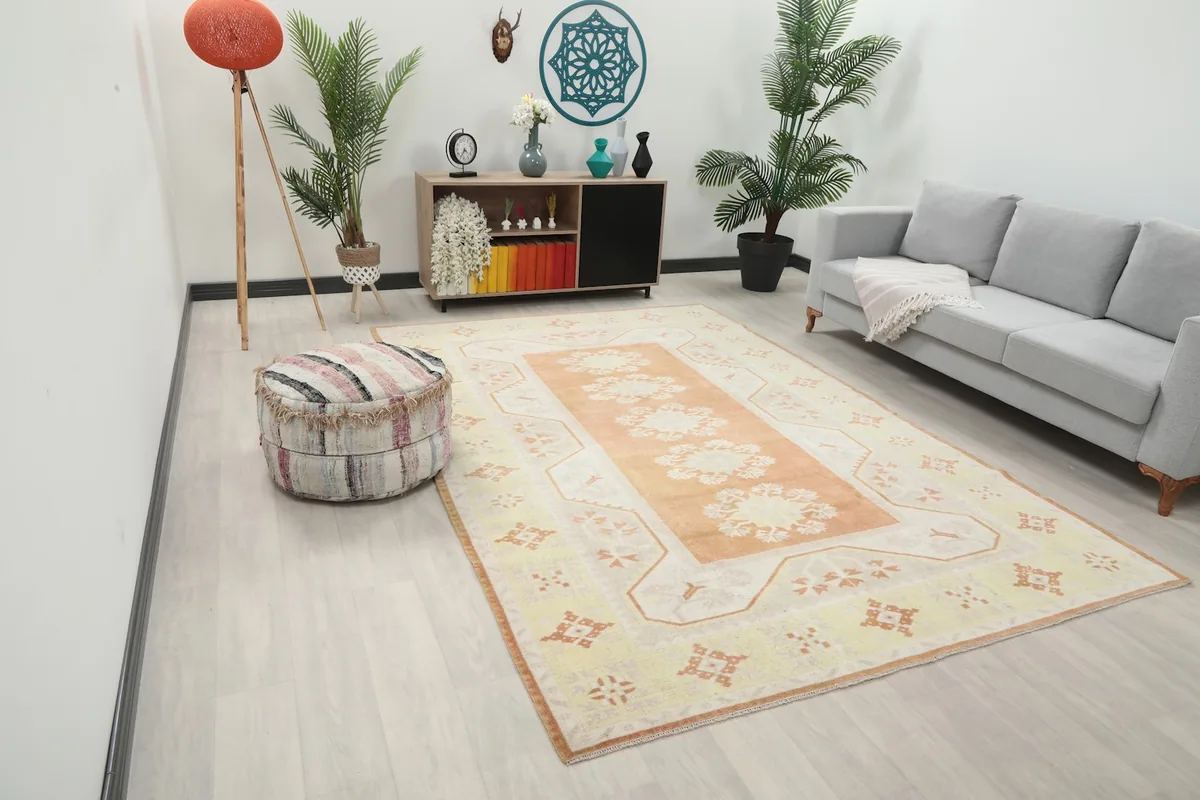 Angle view of the orange and yellow Anatolian rug in a living room, showing its scale with furniture.