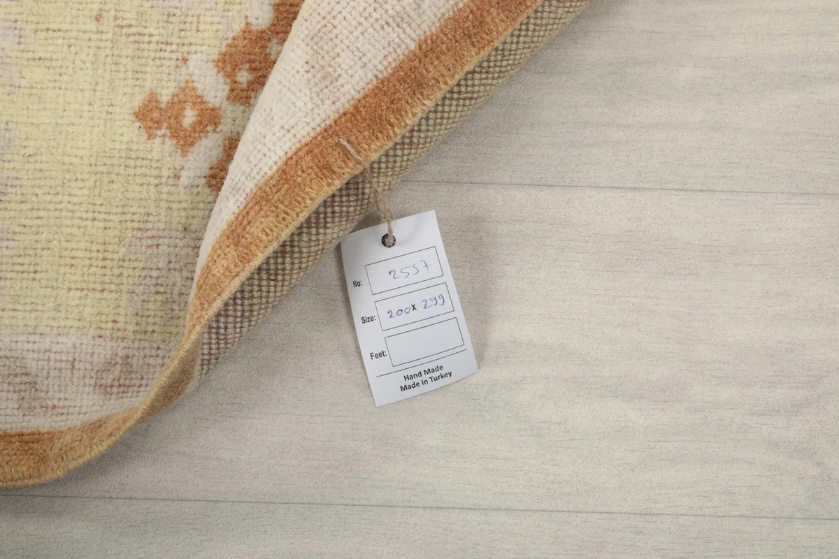 Corner of the rug with the product tag, indicating its origin and hand-knotted nature.