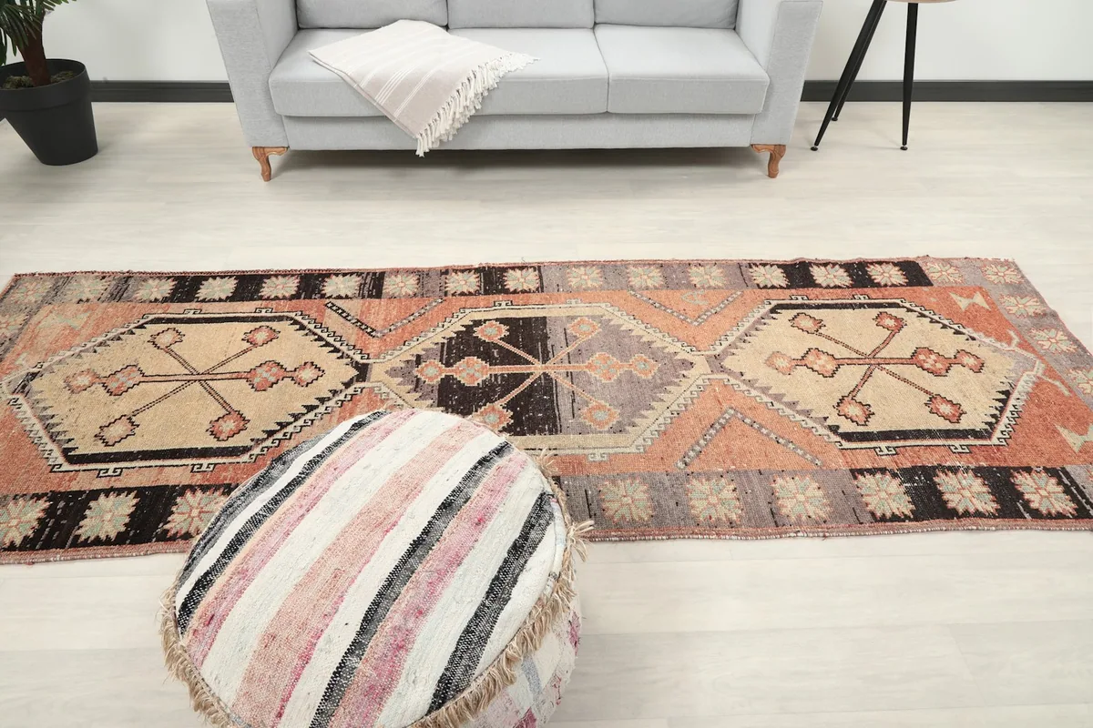 Wide view of the runner rug centered in a room, with a light gray sofa in the background