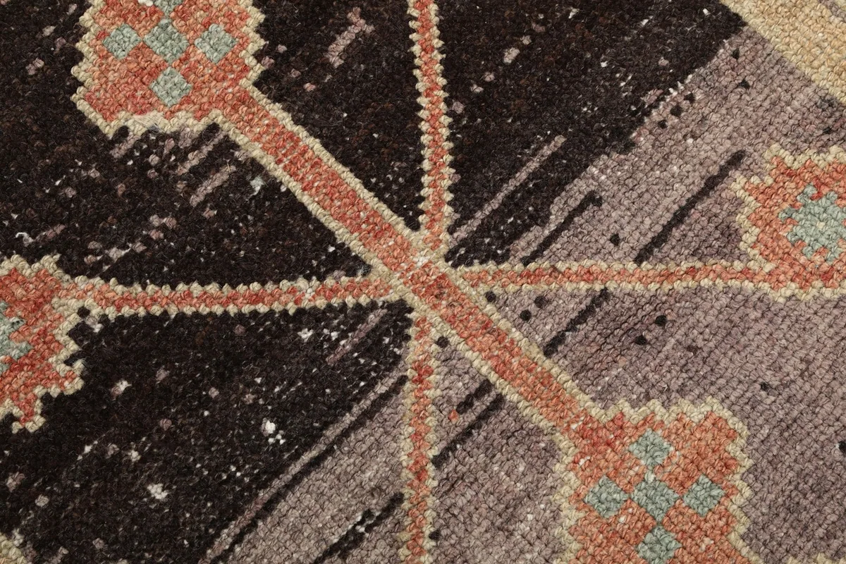 Macro shot of the rug's low wool pile, showing individual knots and color variations