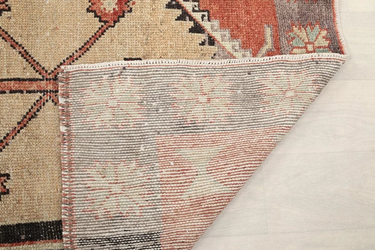 Another view of the folded rug corner, showing the hand-knotted construction