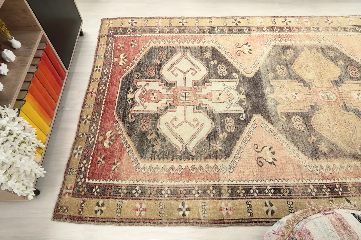 Upper angle view of the rug's patterns and colors, including the rose field and charcoal elements