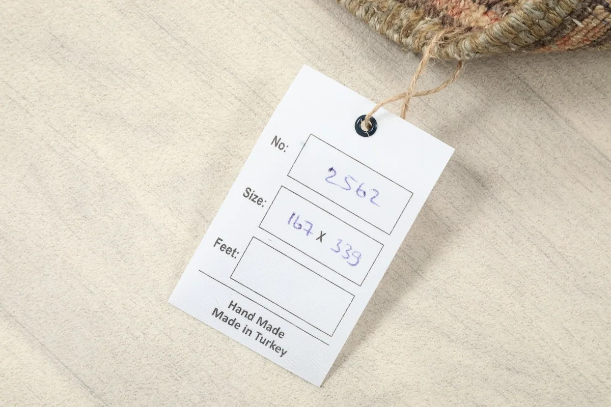 Close-up of the product tag indicating the rug's size in centimeters and its origin as handmade in Turkey