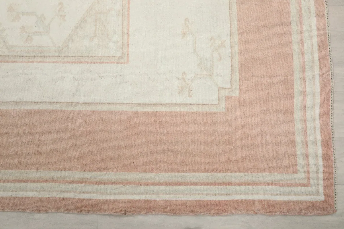 Detailed corner of the rug, highlighting the subtle geometric motifs in ivory