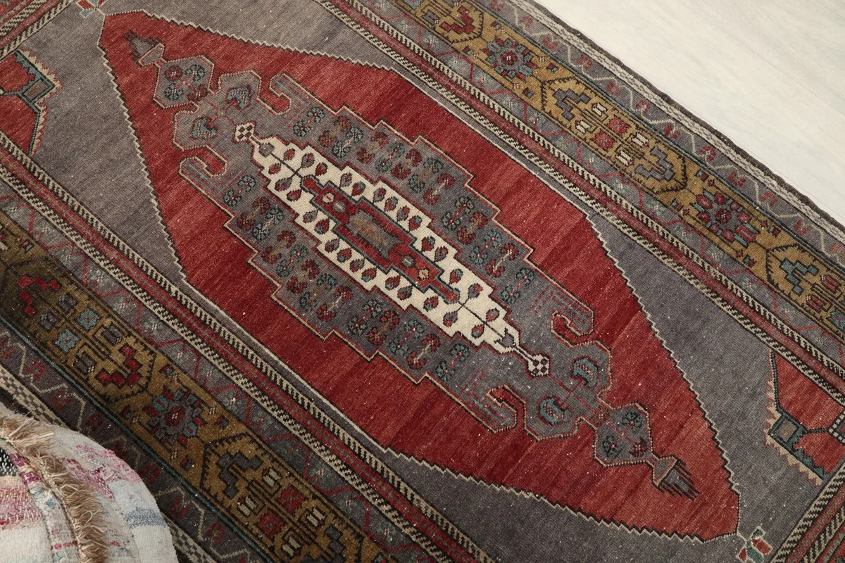 Close-up of the central red medallion and gray field, highlighting the wool pile