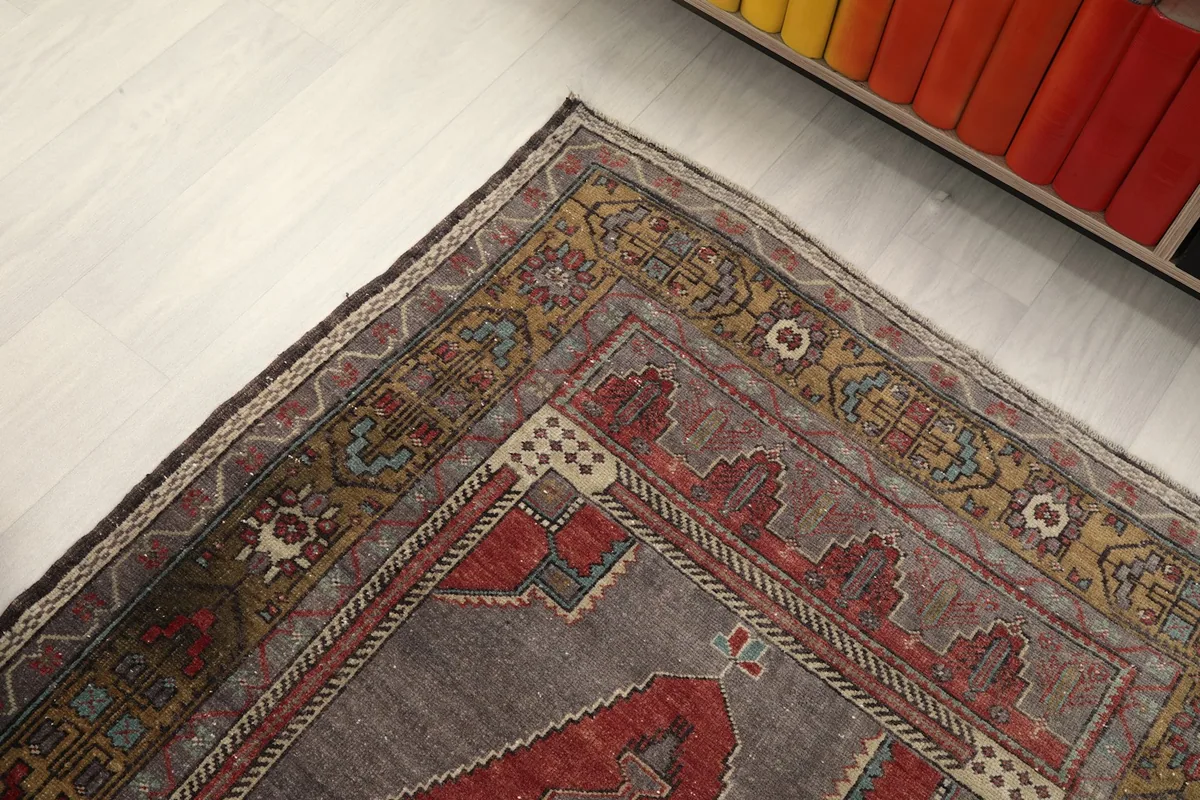 Close-up of the rug's tan and olive border with geometric motifs