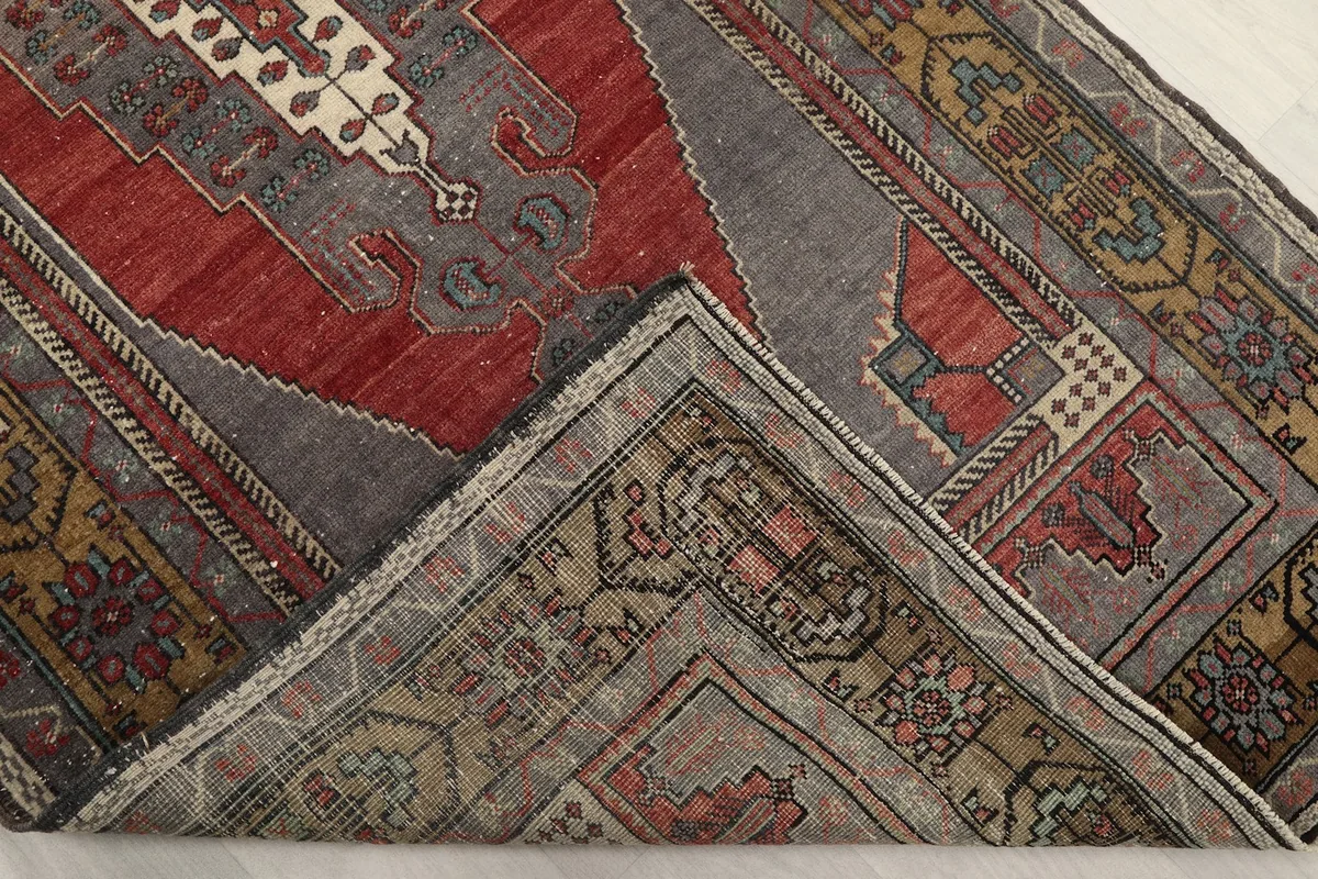 Corner of the rug folded back to show the hand-knotted cotton foundation