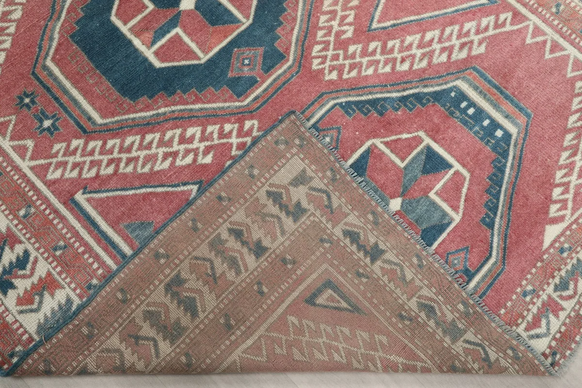Corner of the rug folded back to reveal the cotton foundation and hand-knotted construction
