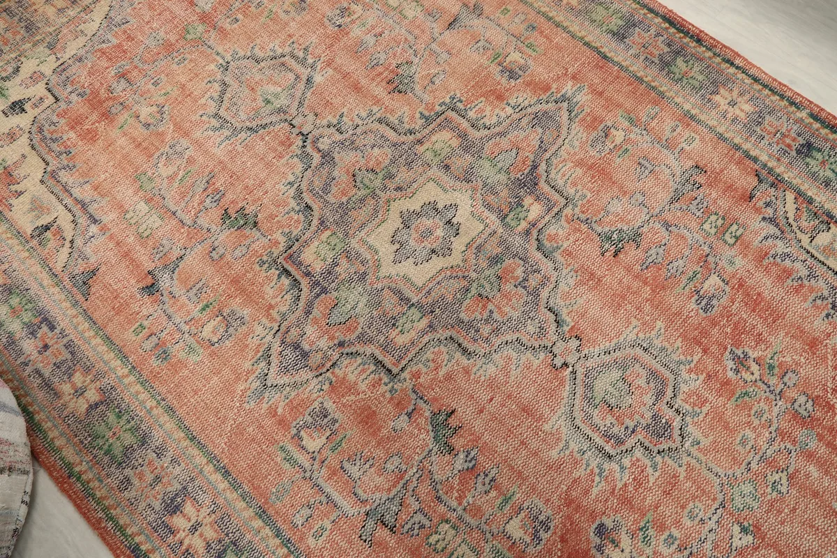 Close-up of the central medallion and surrounding floral details in rust and navy