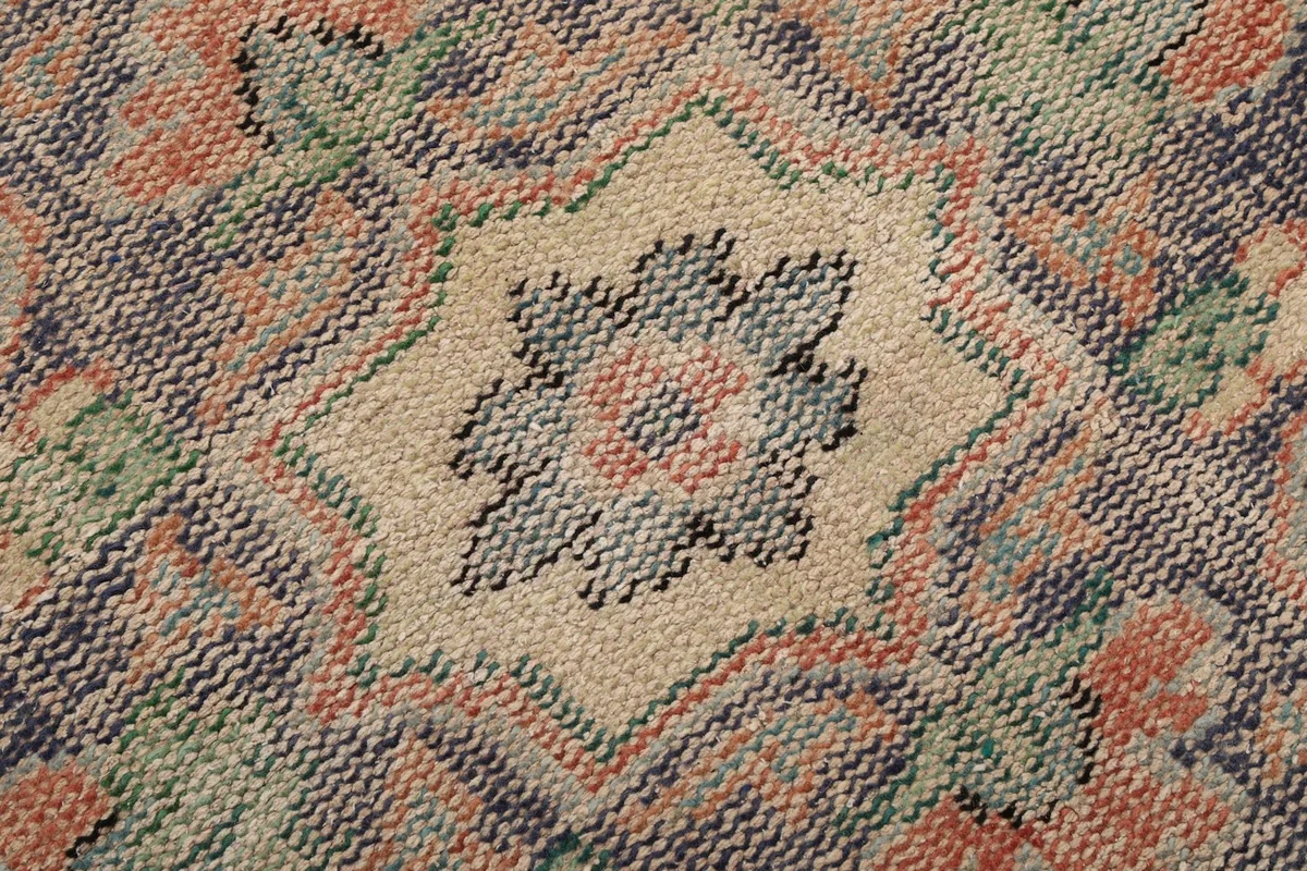 Macro detail of the low pile and hand-knotted wool texture of the rug