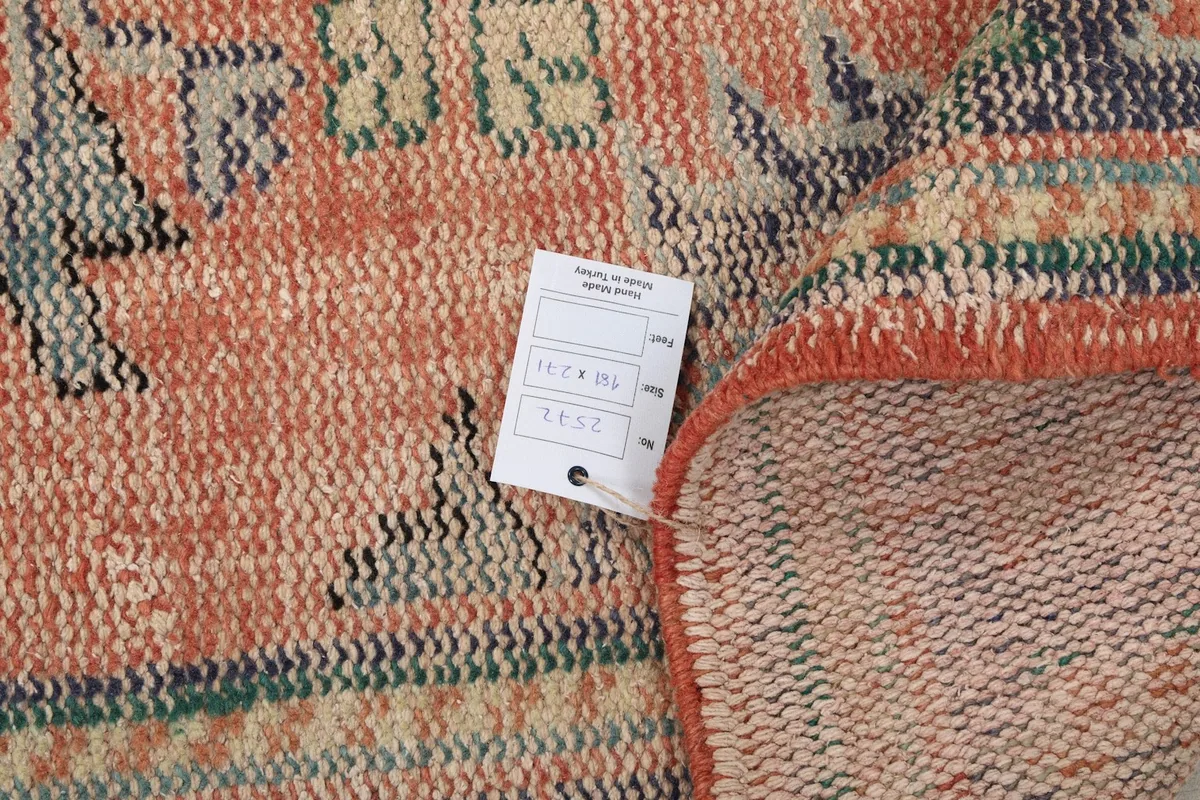 Detail of the rug's edge with a tag, showing the wool pile and cotton foundation