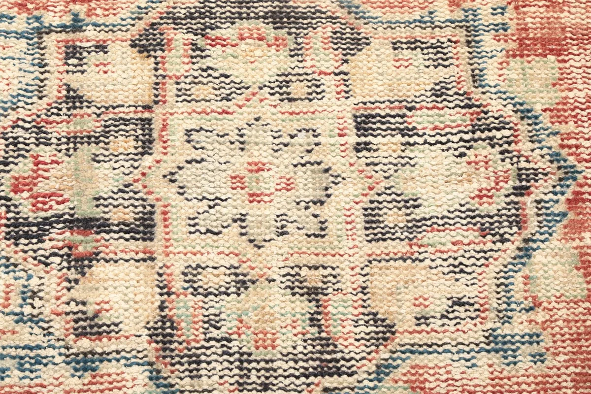 Close-up of the central geometric medallion, showing the intricate wool knots and colors