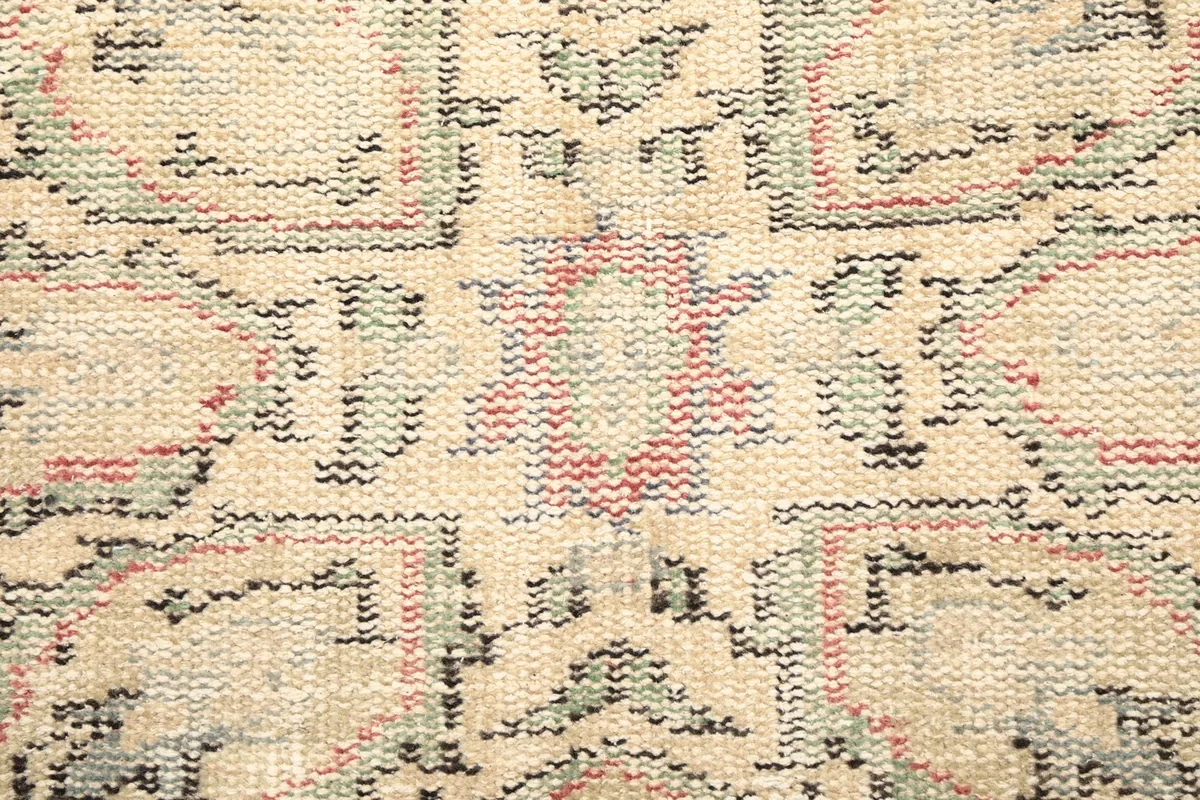 Extreme close-up of the low wool pile and intricate hand-knotted details of the rug