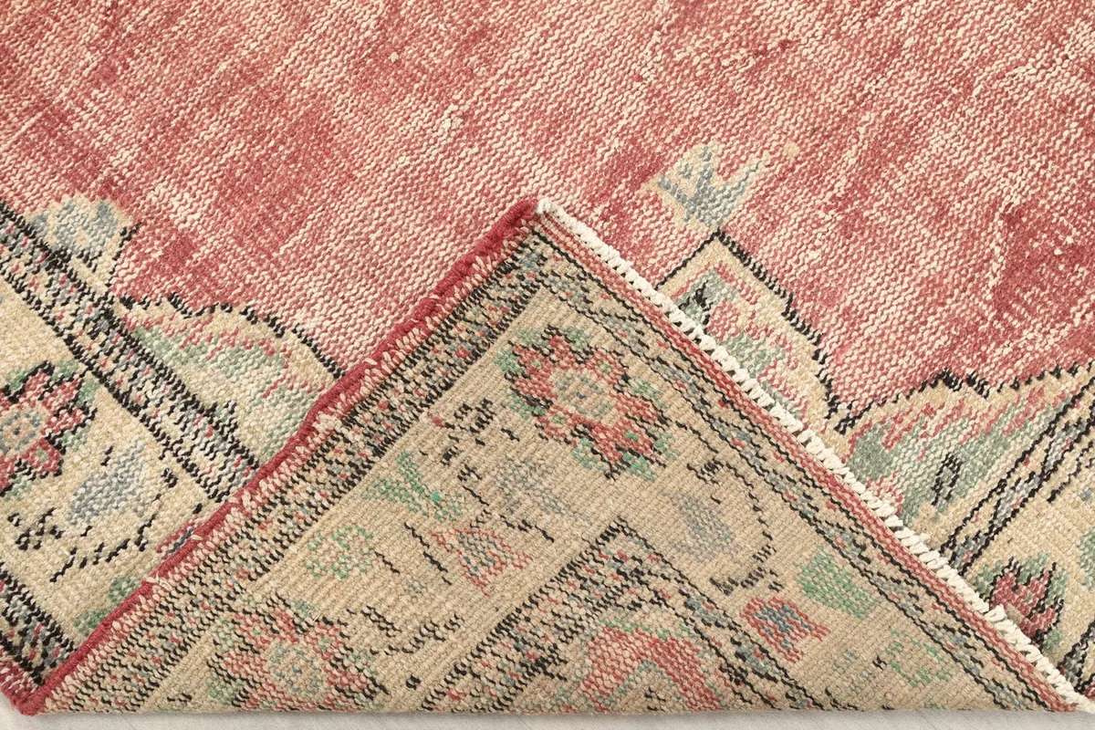 Folded corner of the rug, revealing the thickness and construction of the hand-knotted wool pile