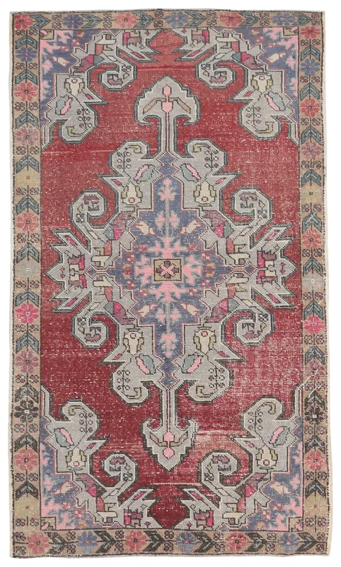 Full overhead view of the vintage Anatolian rug with a red field and central gray-blue medallion