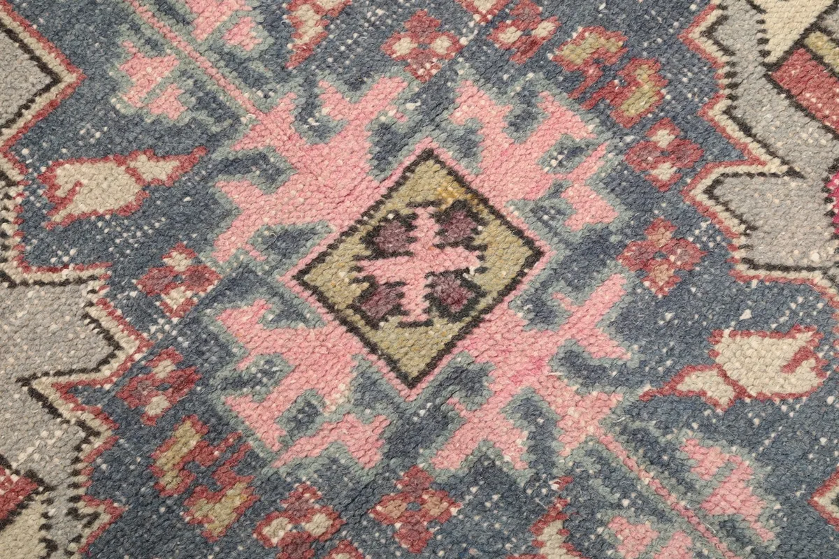 Extreme close-up showing the low pile and intricate knotting of the rug's central design