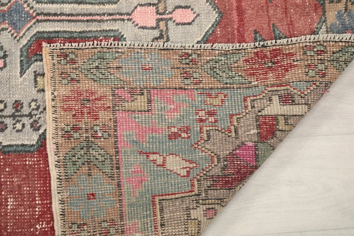 Close-up of the rug's reverse side, showing the tight knotting and color variations from the back
