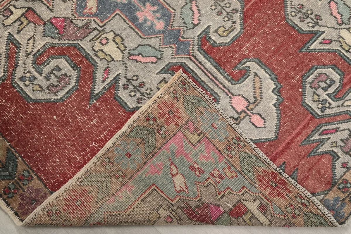Corner of the rug folded back, revealing the reverse side of the hand-knotted cotton foundation
