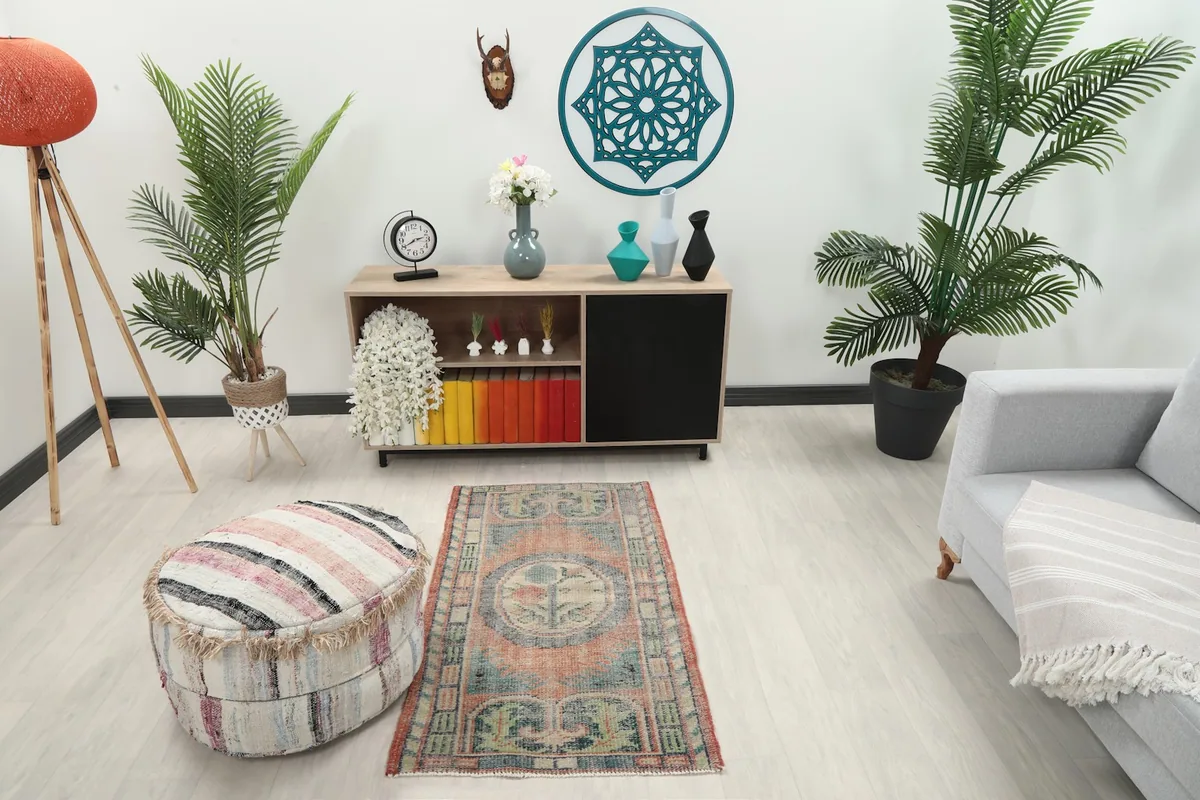 Vintage rust and blue area rug placed in a modern living room setting with a light grey couch.