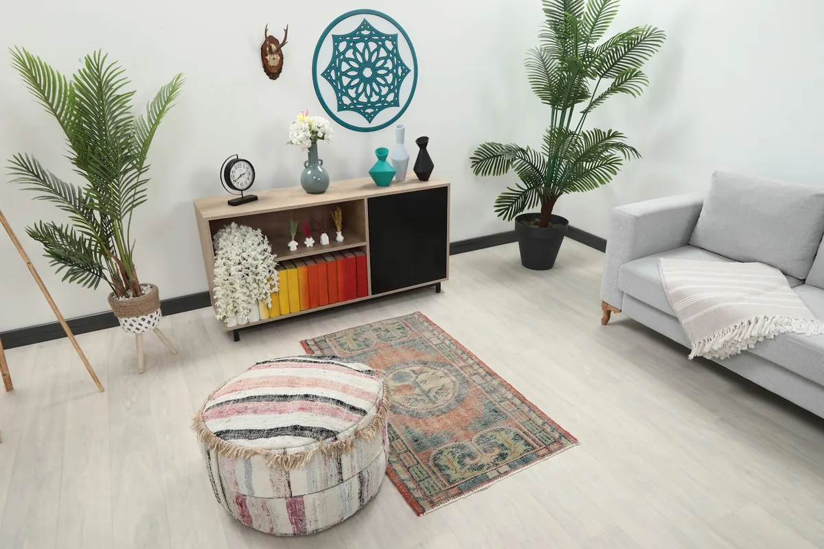 Overhead view of the small vintage rug in a room, showing its placement relative to furniture and plants.