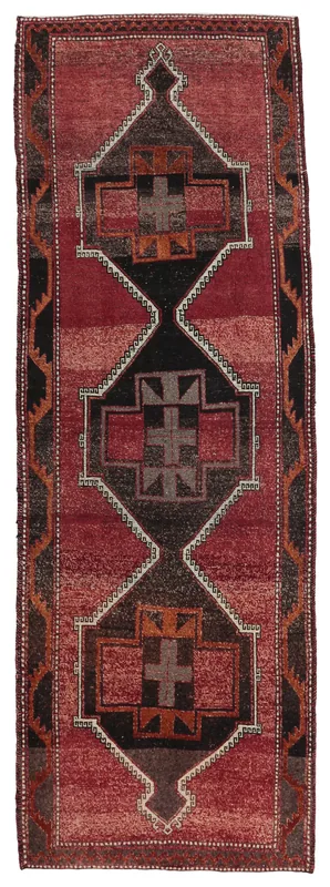 Full top view of the red and black tribal geometric runner rug on a white background
