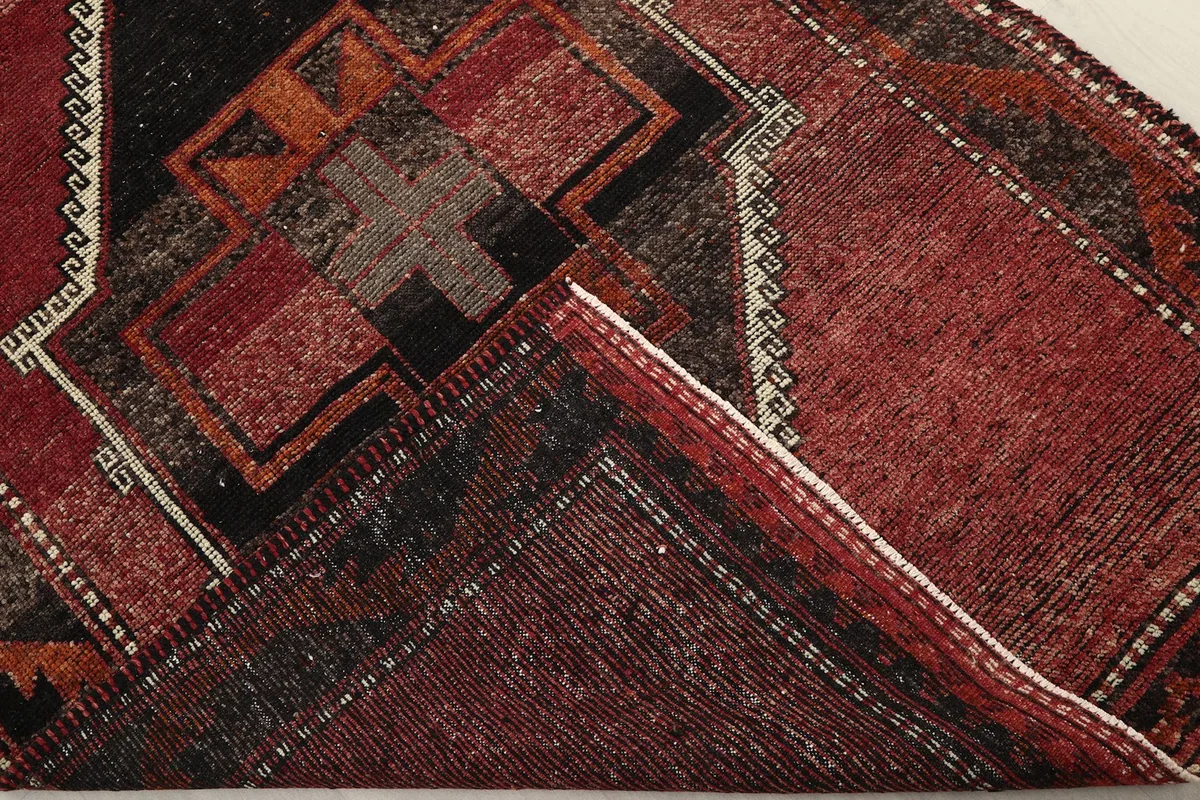 Folded corner of the rug revealing the cotton foundation and hand-knotted construction
