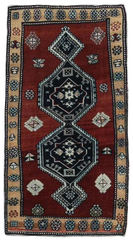 Full top view of a vintage rust and navy tribal medallion rug on a white background.