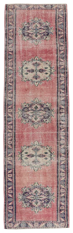 Full top view of the rose and navy geometric Anatolian runner rug on a white background.