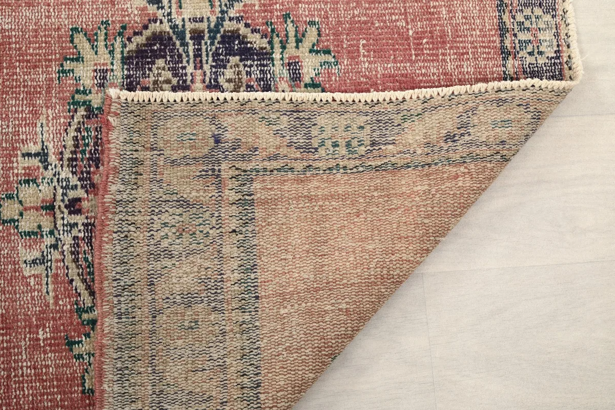 Another view of the rug's underside, showing the tightly woven cotton foundation and craftsmanship.